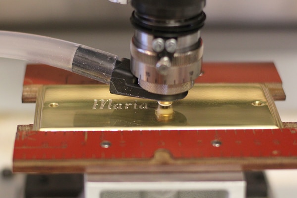 Dybgravering af messingskilt med lakfyldning