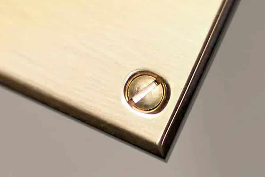 Messingskilt med skruehuller til montering på dør eller væg